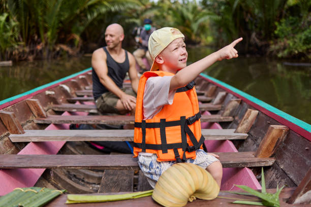 istock A little boy sits on a boat with a life jacket and points his finger 2081947038