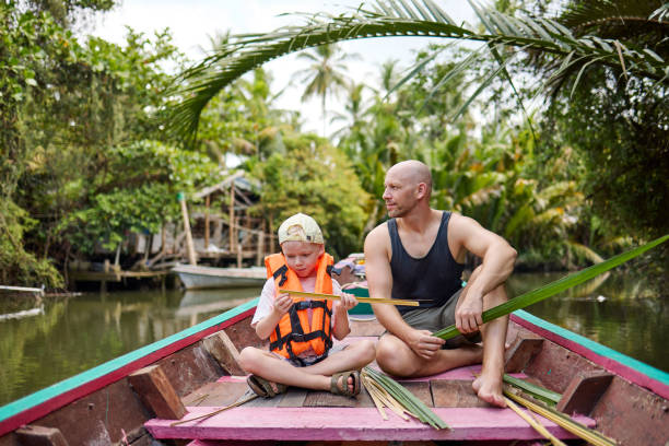 istock A father sits with his son on a longtail boat during a trip on a canal 2081950787