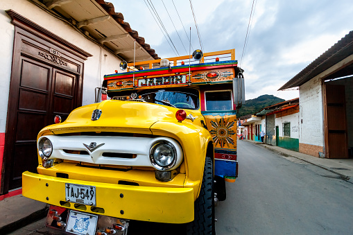 Jardin, Colombia - January 12, 2023: Typical truck, called chiva, parked on a corner of the town waiting for passengers