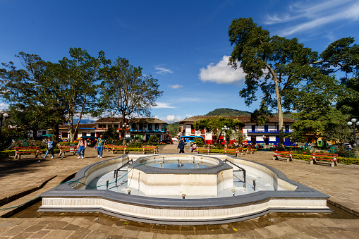 Jardin, Colombia - January 13, 2023: Tourists and residents walk through the main park of the town