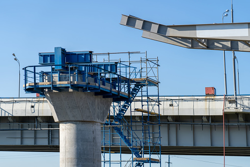 New highway bridge under construction. Connection of steel powerful straight crossbar, bridge connection, metal architecture