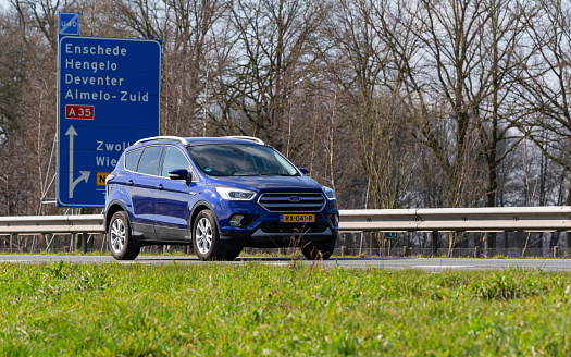 Netherlands, Overijssel, Twente, Wierden, March 19th 2023, side/front view close-up of a Dutch blue 2018  Ford 2nd generation Kuga SUV driving on the N36 at Wierden, the Kuga has been made by American car manufacturer Ford since 2008, the N36 is a 36 kilometer long highway from Wierden to Ommen