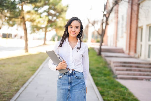 istock young asian female student walking to her class with book and notebook in hand on university campus 2081999439