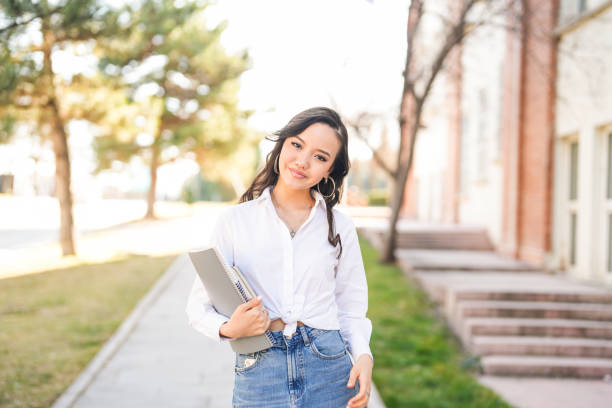 istock young asian female student walking to her class with book and notebook in hand on university campus 2081999440