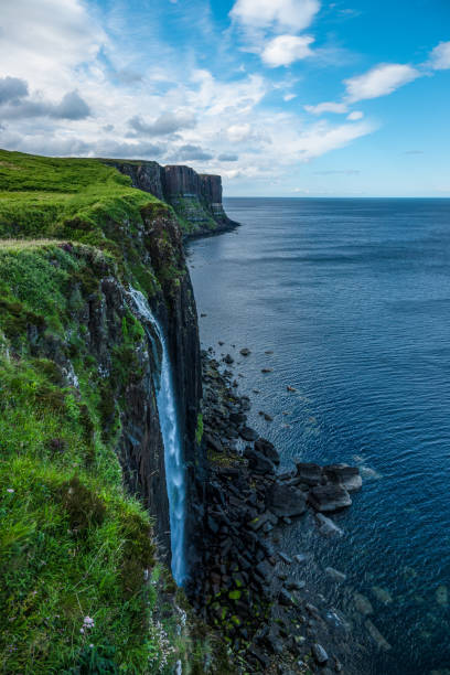 istock Stunning coastline with high cliffs and waterfall cascading down to rocky shore 2082006294