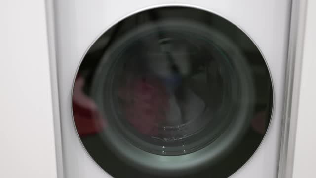 Close up view of a modern washing machine in operation, showcasing the laundry process.