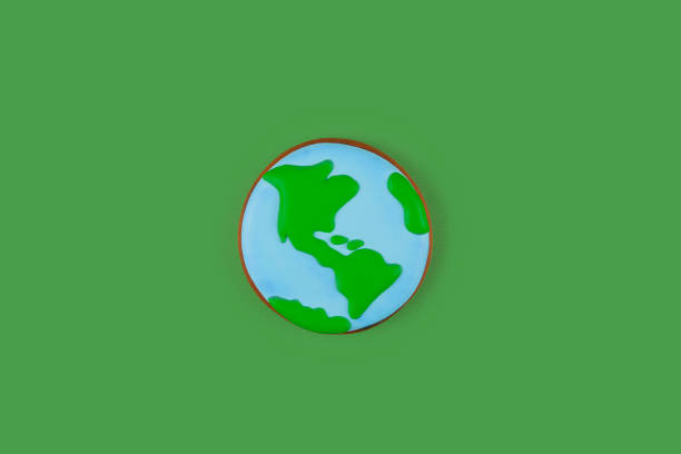 istock Earth Day concept. Single cookie in shape of Earth on green backdrop. 2082022674