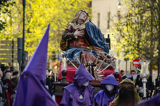 Procession, Holy Week, Paso Nuestra Virgen de la Amargura, runs through the streets of the city of Valladolid on Holy Thursday afternoon with hoods and penitents. Valladolid, Spain - April 14, 2022.