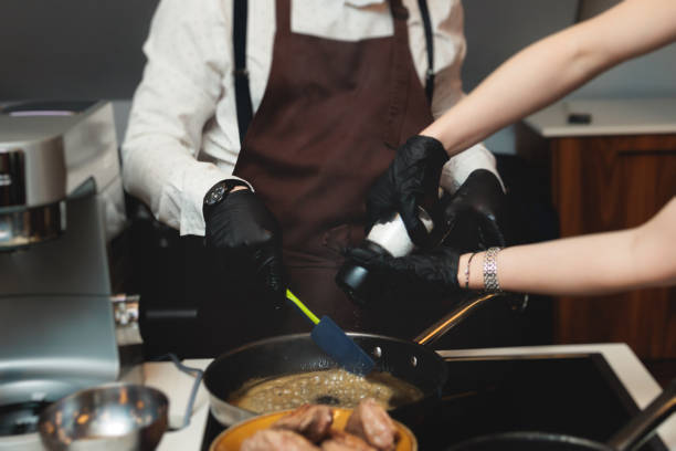 istock Group of guests in a cooking class studio, adults preparing different dishes in the kitchen together, people in aprons learn on culinary master class, chef uniform, hands in gloves, italian cuisine 2082023750