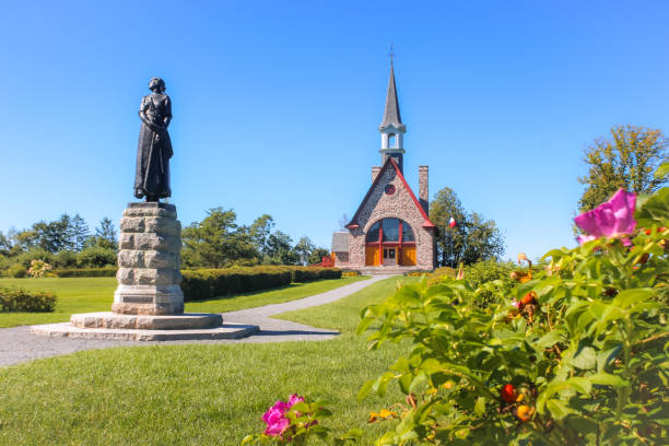 Grand-Pré, Nova Scotia - August 2023: The Memorial Church in Grand-Pré National Historic Site, it was built in 1922. It commemorates the area as a centre of Acadian settlement from 1682 to 1755 and the Deportation of the Acadians, from 1755 and continued until 1762. The statue is of Evangeline, a young woman who was separated from her partner during the deportation. She became a symbol of the events and the Acadian people.