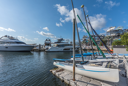 Luxury boats and modest recreational catamarans in the Miami marina on a sunny morning.
