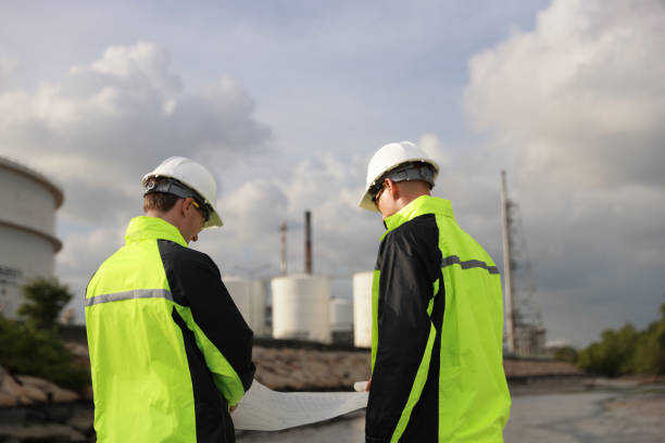 istock The oil industry engineer team with blueprints is discussing the plan work at the front refinery industry. 2082051997