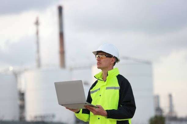 istock engineer wearing a green safety jacket holding a laptop working at the front construction, engineering, and technology 2082052015