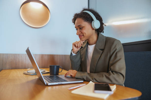 istock A whitecollar worker with headphones is using a laptop at a desk 2082168850