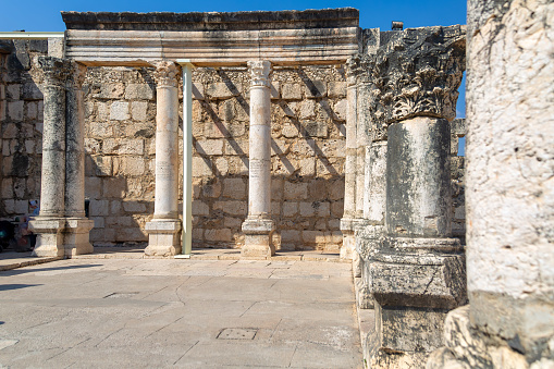Old weathered stones and columns of synagogue on the Sea of Galilee.