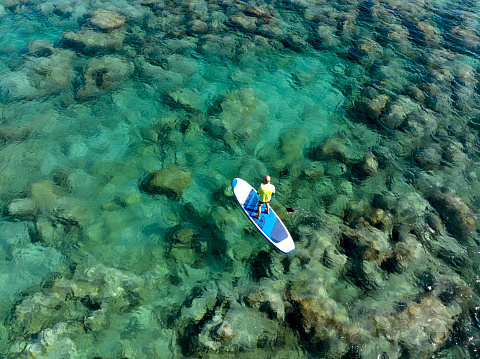 Aerial view of woman floating on a stand up paddle