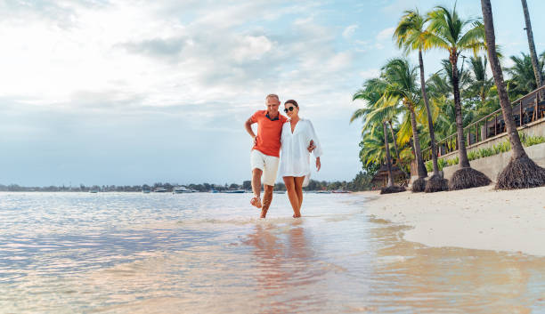 istock Couple in love hugging while walking on a sandy exotic beach. They have an evening walk by Trou-aux-Biches seashore on Mauritius island. People relationship and tropic honeymoon vacations concept 2082302833