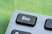 Macro shot showcasing of an Esc key of a modern keyboard, object detail, extreme closeup macro, nobody. Escape character button, escaping, closing an app, cancelling simple abstract concept, no people