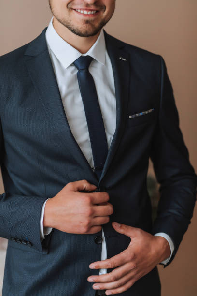 istock Confident elegant handsome guy standing at home and buttoning his jacket looking at the camera in a nice dark blue suit 2082308521