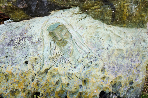 Close-up shot of a stone face carving at one of the islands of Tota Lake.