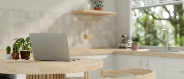 istock A back view image of a laptop computer on a wooden dining table in a minimalist neutral kitchen. 2082372121