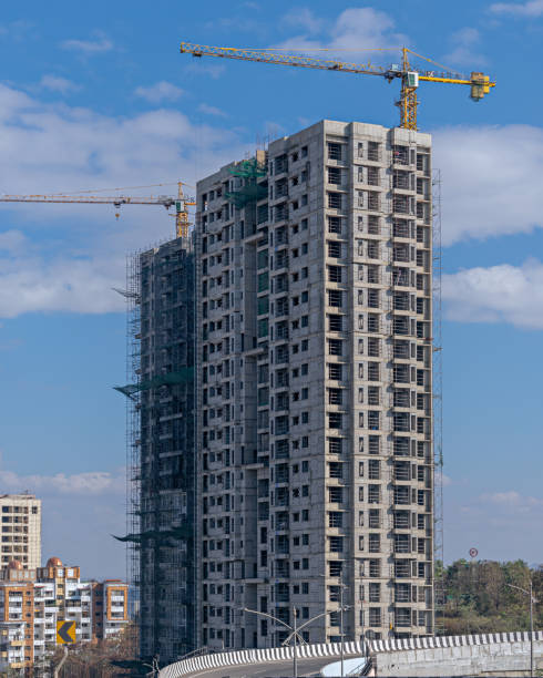 Beautiful blue sky behind two tall buildings in Sunlight , under construction in fast growing city of Pune, India.
