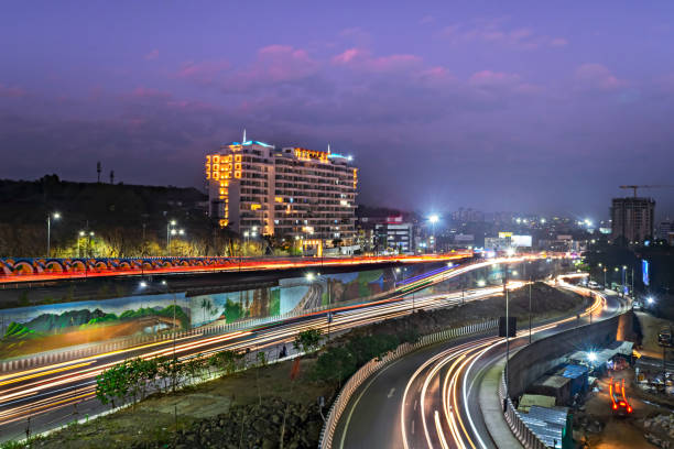 istock Slow shutter speed image of light trails, beautiful sunset sky , buildings and flowing traffic on newly developed motorway junction. 2082382108