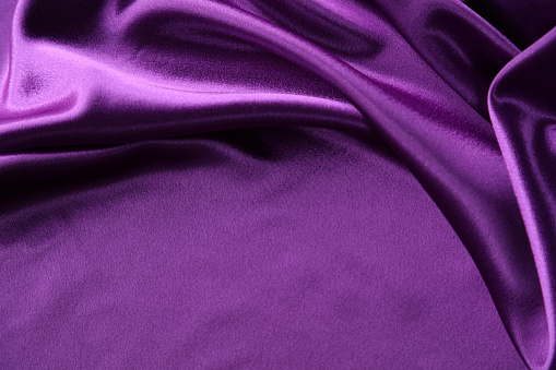 Close-up of ripples in purple silk fabric