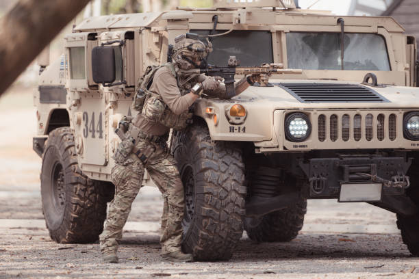 istock Soldiers in camouflage uniforms hold weapons ready to fire 2082441123