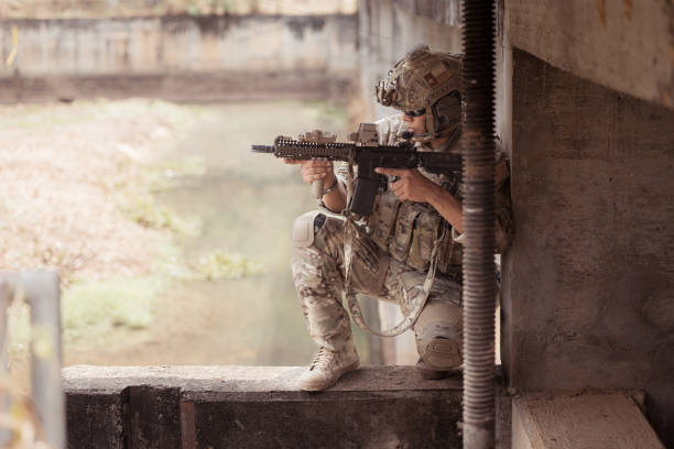 Soldiers in camouflage military uniforms carrying weapons, Reconnaissance missions in the tropical forest area, Assault infantry battle training.