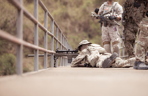 Soldiers in camouflage military uniforms carrying weapons, Reconnaissance missions in the tropical forest area, Assault infantry battle training.