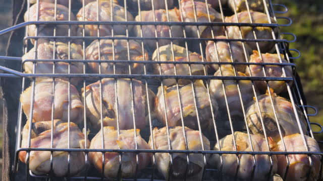 Bacon wrapped champignons grilling with smoke, backyard, slow motion. Weekend party, mushrooms in bacon are grilled