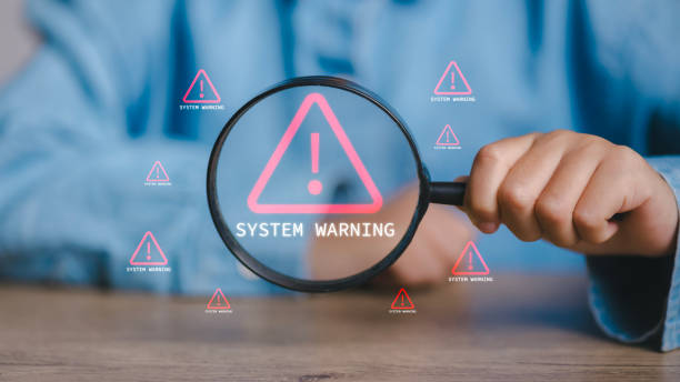 istock A person is holding a magnifying glass over a computer screen that says System W 2082546554