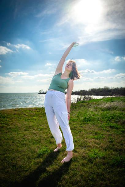 istock woman stretching in the grass on the lakshore 2082660948