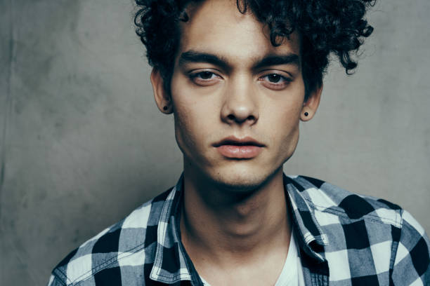 istock cute guy portrait curly hair emotions gray background model 2082741689