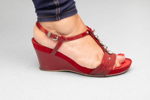 Detail of Toes with Red Polish and Band-Aid on a Pebble Beach – Traces of Summer Wear