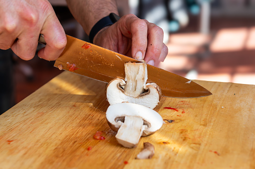 Culinary mastery: Chef slicing mushrooms with precision.