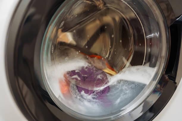 istock Closeup of washing machine door with spinning laundry 2082820292