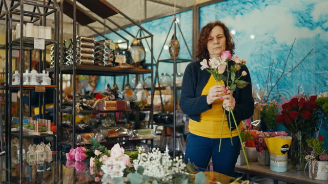 Mature Female Florist Arranging Flowers to Create a Beautiful Bouquet at Her Shop