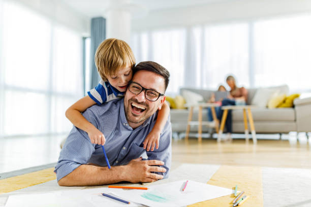 istock Happy father and son enjoying while coloring on floor at home. 2082864727