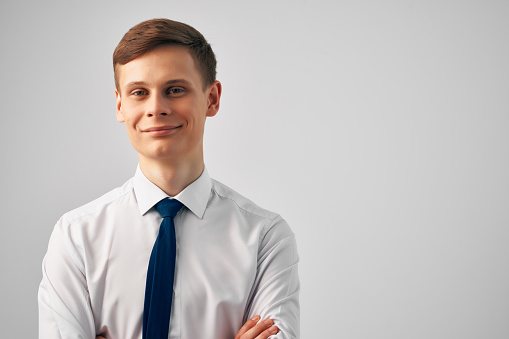 Portrait of a handsome positive caucasian successful bearded business man in a suit, seo, banker, broker, standing over isolated white background with arms crossed, looking at camera, smiling friendly