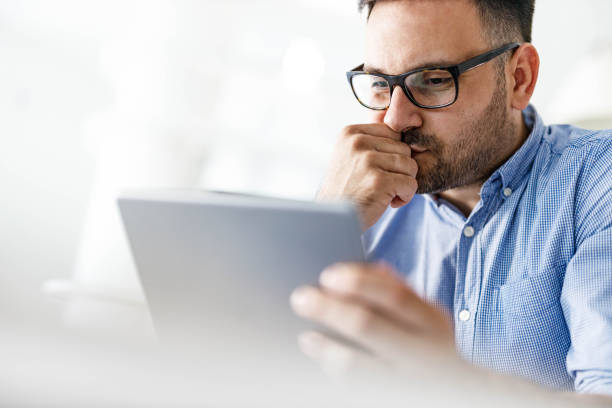 istock Young man working on a touchpad at home office. 2082872589