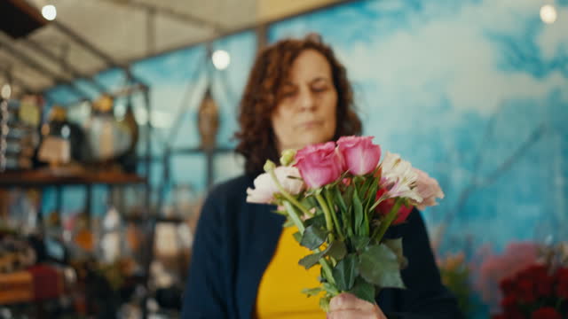 Closeup of Mature Female Florist Creating a Beautiful Bouquet at Flower Shop
