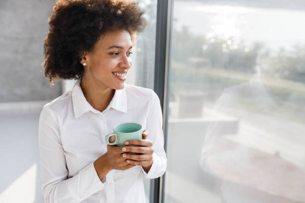 istock Pensive black woman looking through window during home isolation. 2082885852