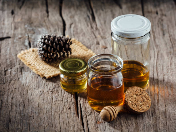 Honey in a glass bottle on a wooden background stock photo