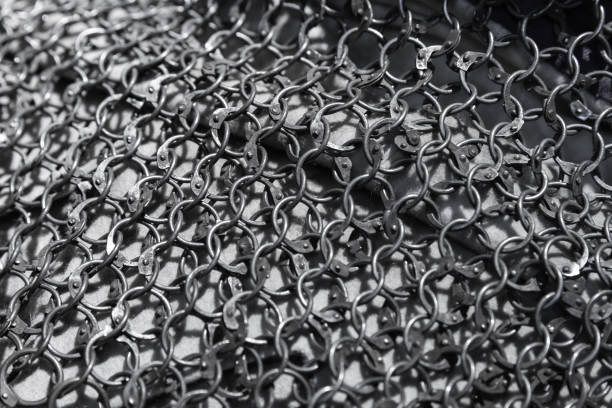 Medieval knight torso armor made of linked iron rings. Chain mail lays over rough white fabric