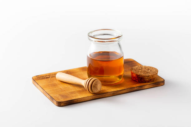 Honey in a glass jar on white background stock photo