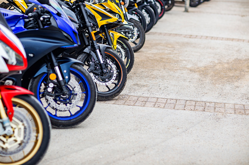 Group of motorbikes parked in a row on parking lot outdoors copy space