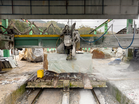 Marble sawing machine in a factory. Cutting marble block.