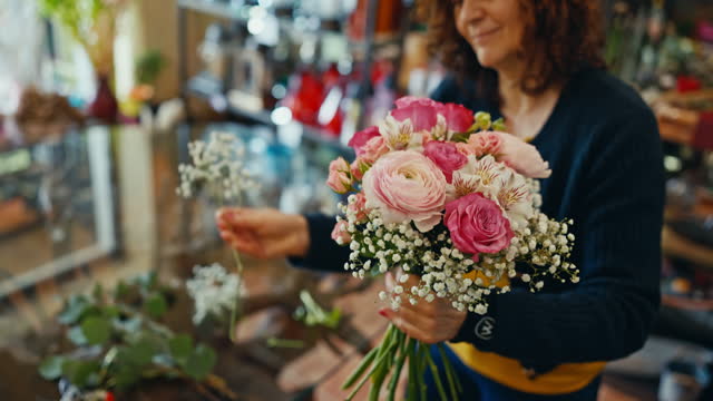 Smiling Mature Female Entrepreneur Making Beautiful Bouquet with Different Flowers in Shop